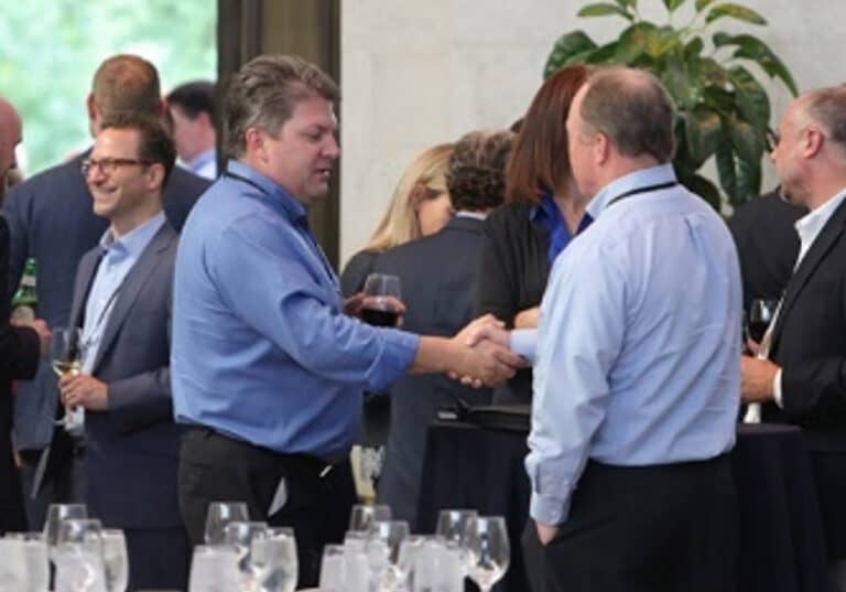 two men shaking hands during a conference social