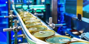 Canned food products on conveyor belt in distribution warehouse.